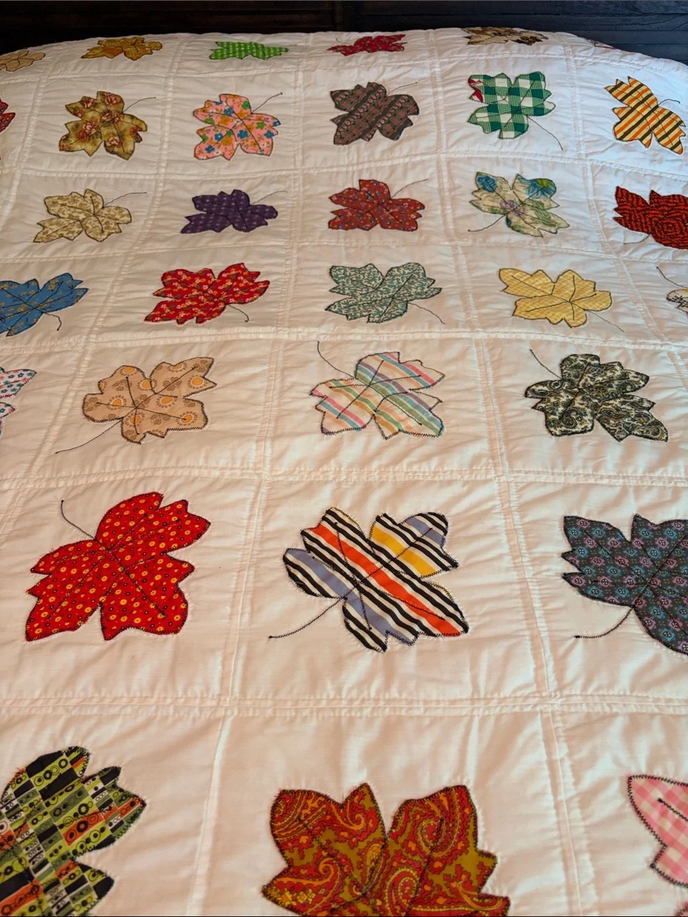 Vintage quilt handcrafted with color leaf blocks on white with green trim